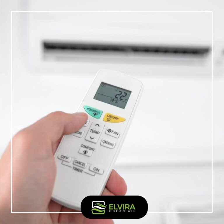 Hand holding a heat pump remote control