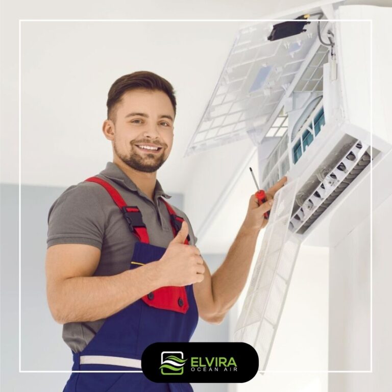 Technician smiling next to a wall air conditioner